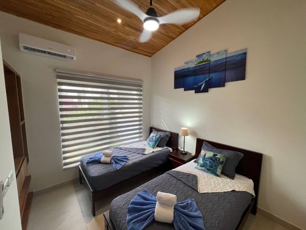 Beautiful bedroom #3 with two twin beds, AC and ceiling fan.