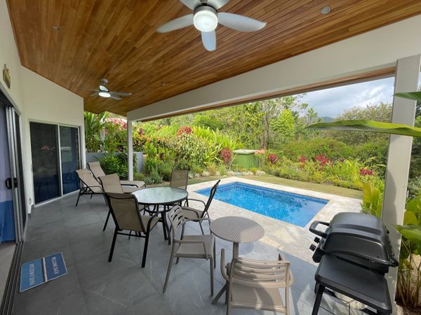 An inviting poolside space featuring comfortable outdoor seating and a BBQ grill.