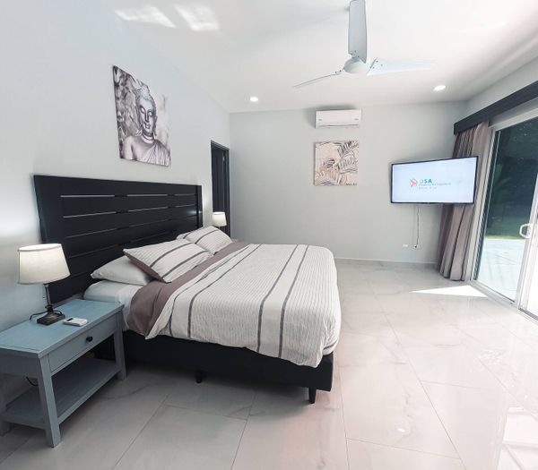 The master suite offers panoramic views of the pool, blending comfort and relaxation.