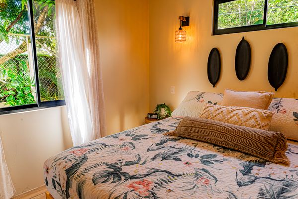 A stylish master bedroom with expansive windows that bring the beauty of nature inside.