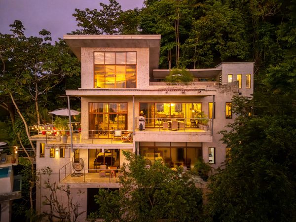 The soft, golden glow of the sunset dances across the windows, filling the house with warmth
