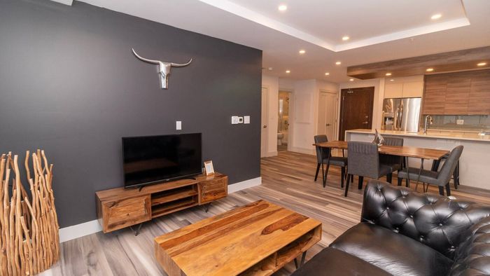 Unwind in the stylish living room with expansive skyline views. Settle into the cozy seating and enjoy your favorite shows on the Smart TV.