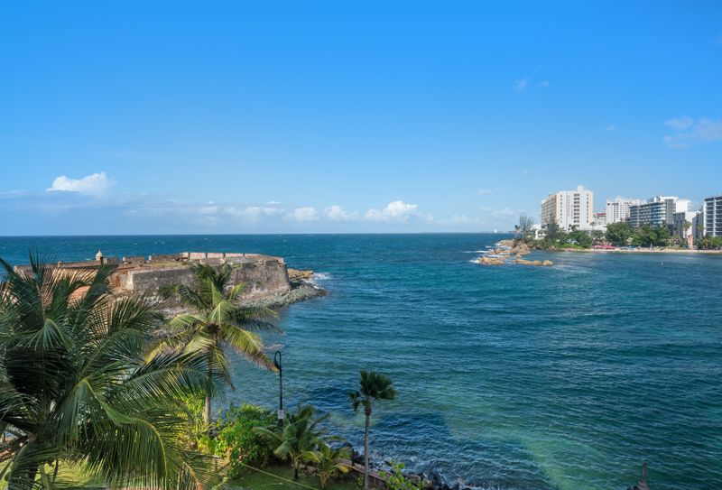 Step into a sun-drenched sanctuary with expansive ocean views through floor-to-ceiling glass doors, creating an open and airy atmosphere.