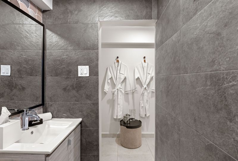 This minimalist bathroom offers a spa-like ambiance with its neutral color palette, clean lines, and luxurious amenities for a relaxing retreat.