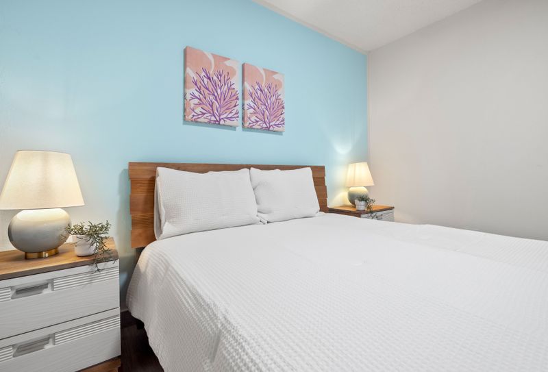 Inviting, pristine queen bed with charming coastal decor for restful nights.