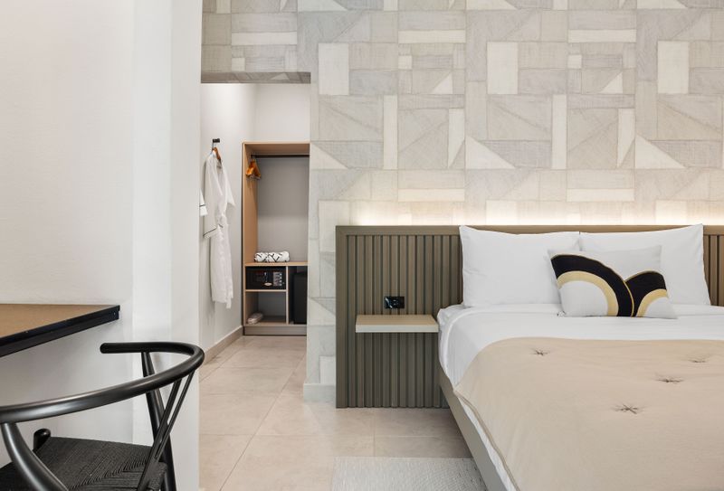 This well-lit bedroom offers a dedicated workspace with a desk and chair, perfect for catching up on emails or remote work.