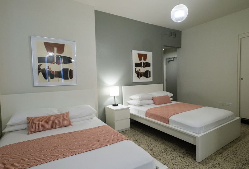 Experience a blend of modern aesthetics and cozy comfort in this inviting bedroom, complete with a comfortable bed and artistic touches that make it feel like home.