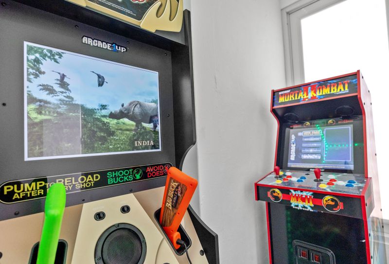 Explore your love for gaming in this stylish space, showcasing classic arcade machines and a magical glow from LED lights.
