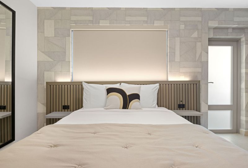 A comfortable haven for rest and relaxation, featuring a plush bed with crisp white linens and a soft quilt