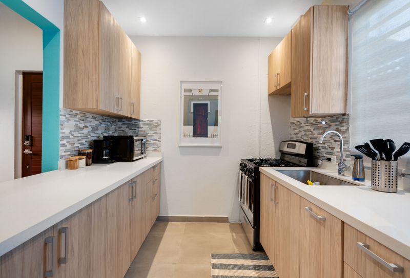 A bright and roomy kitchen with elegant countertops and plenty of storage space.