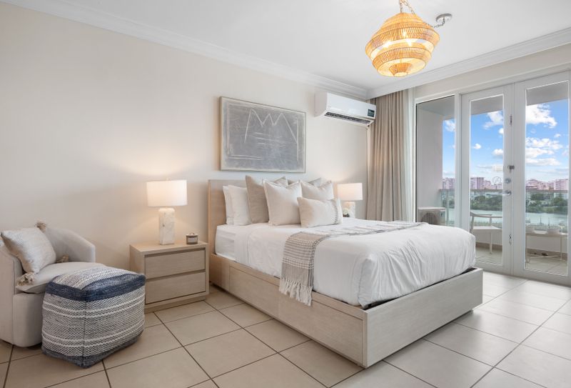 Relax in comfort on your plush, king-sized bed, featuring serene decor and ample light.