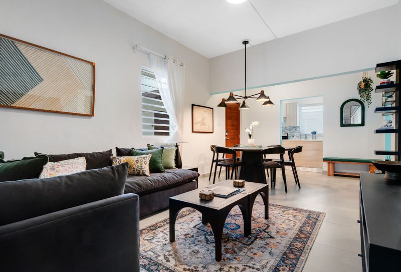 A tastefully designed living area with a wooden dining table and abundant natural light.