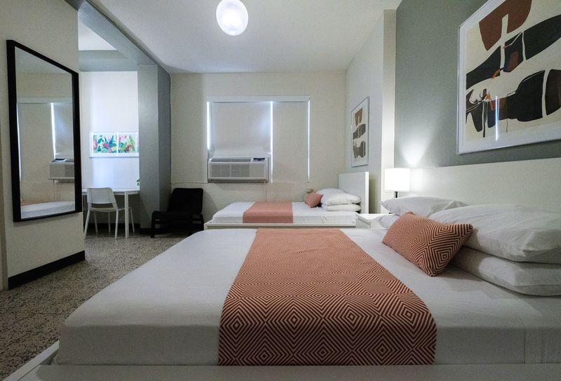 Experience a blend of modern aesthetics and cozy comfort in this inviting bedroom, complete with a comfortable bed and artistic touches that make it feel like home.