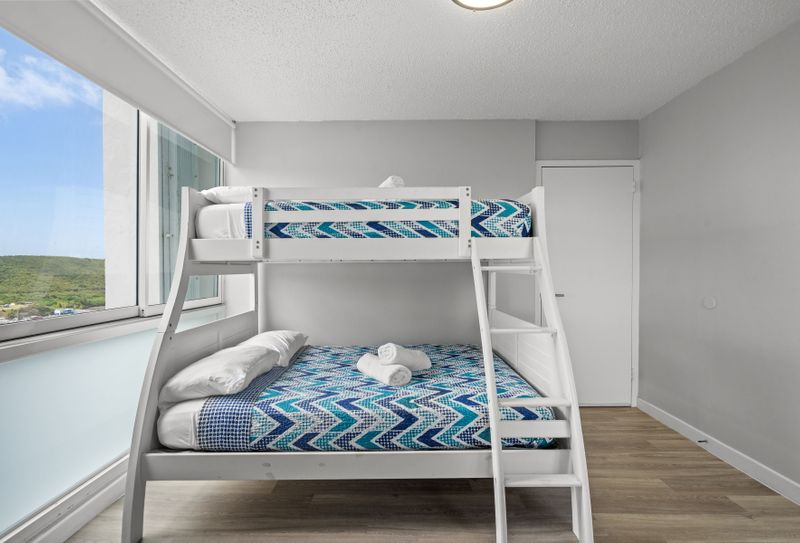 Marina | Beachfront Rental 4 Perfect for multiple guests! Our spacious bunk bed room provides comfortable and sturdy sleeping options, ensuring everyone has their own space to relax.