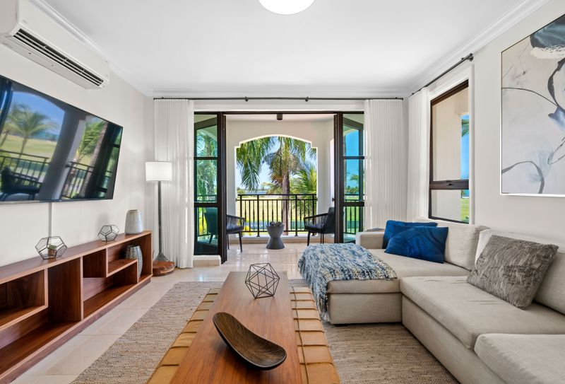 This living space is all about modern elegance and comfort. It features a plush sectional sofa, a sleek coffee table, and a big flat-screen TV, perfect for relaxing or entertaining. The standout feature is the amazing golf course view from the sliding glass doors that open to a private balcony. The neutral colors and natural light make it feel calm and stylish.