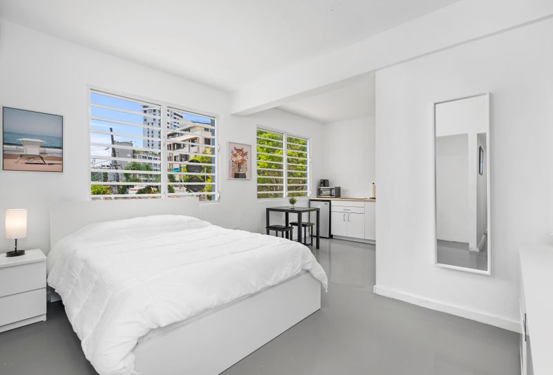 Condado | Near The Beach Condo 2 The large window invites natural light, and the air conditioner ensures a pleasant stay. Unwind in comfort with a spacious bed, sleek design, and contemporary style awaiting you.