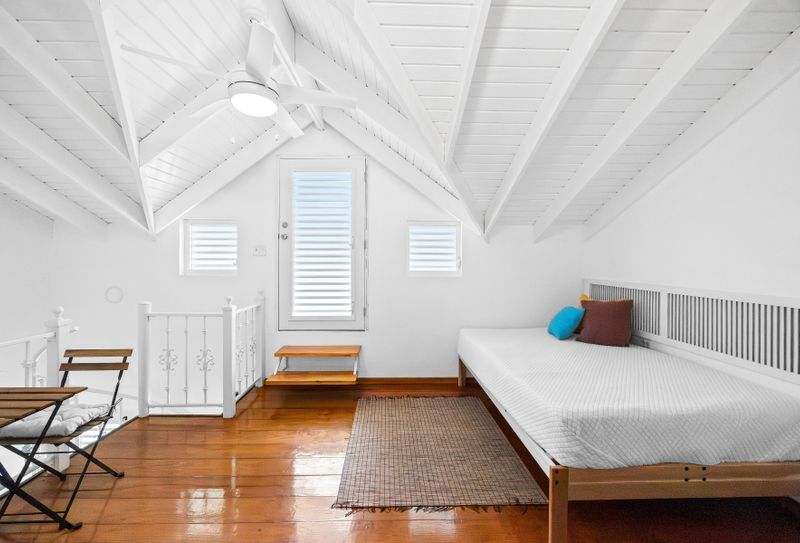 Cozy and clean bedroom with soft linens, air-conditioning, and serene white decor – your peaceful home base for a restful sleep.