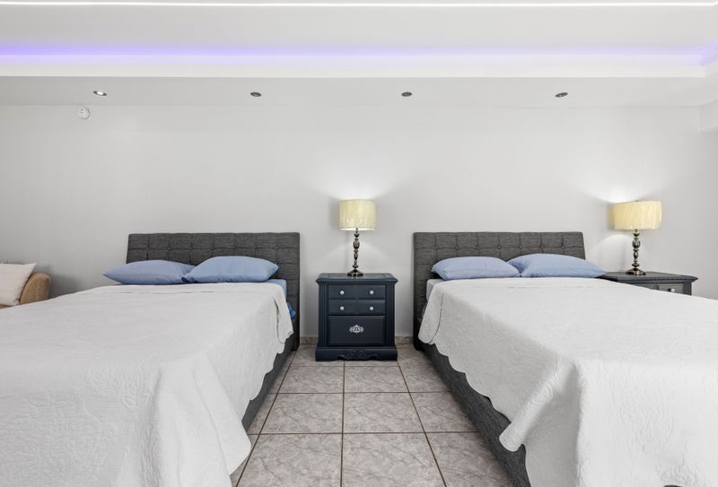 Modern double bedroom with a soft linens and bedside lamp. Perfect for relaxation.