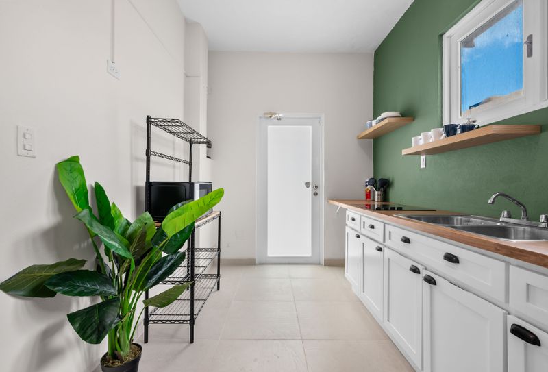 Modern, clean kitchen with open shelving and ample counter space.