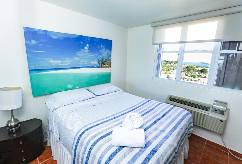A serene bedroom bathed in soft natural light, featuring a crisp white bed with minimalist bedding.