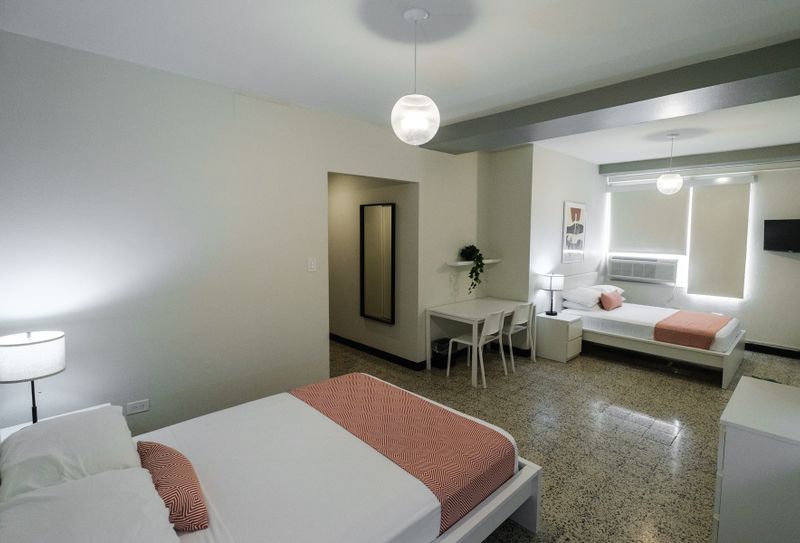Discover a roomy and well-lit space, offering a comfortable bed and a full-length mirror, perfect for getting ready to explore or simply unwinding.