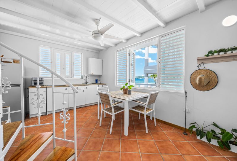 Island-style kitchen with cozy dining space with dining table, ceiling fan