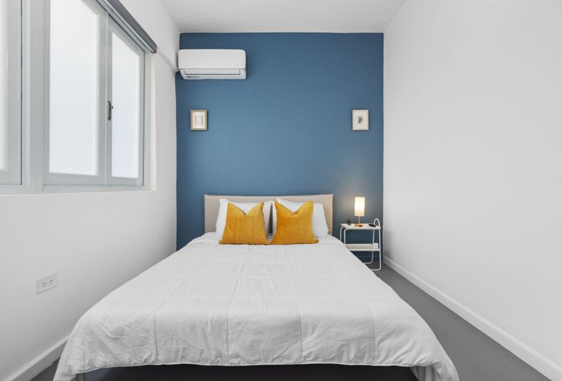 Your Serene Escape Awaits: This charming bedroom offers a tranquil ambiance with its chic minimalist design and comfortable, spacious bedding—perfect for a restful night.