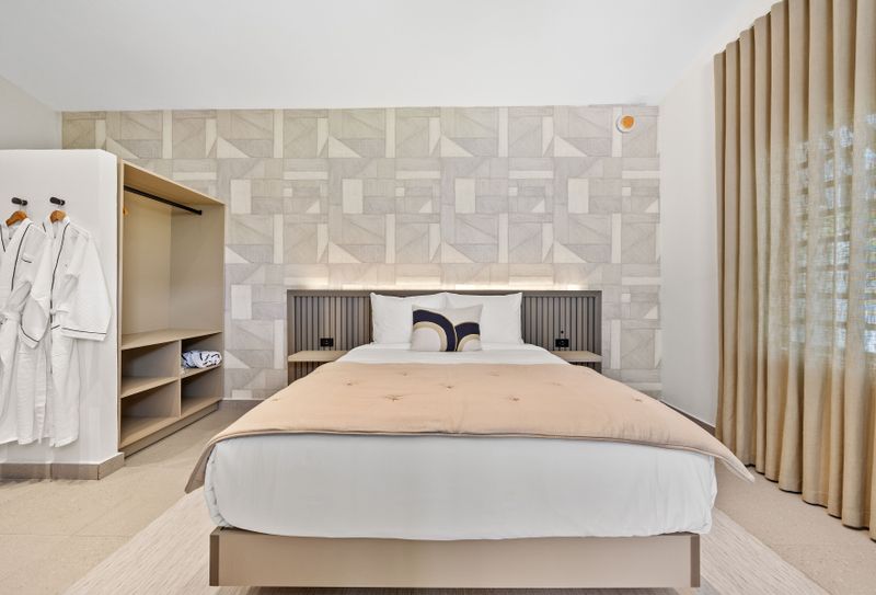 Bright and airy bedroom with a queen-sized bed, a desk, and a closet.