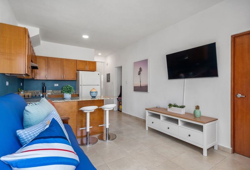 A flat-screen TV is mounted on a wall opposite the sofa, creating a harmonious and functional space.