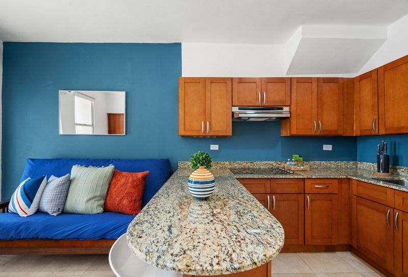 Inside a well-lit apartment, the living area flows seamlessly into an open kitchen.