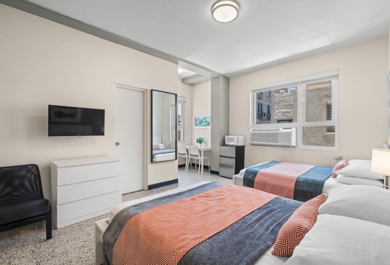 Experience a blend of modern aesthetics and cozy comfort in this inviting bedroom, complete with a comfortable bed and artistic touches that make it feel like home.