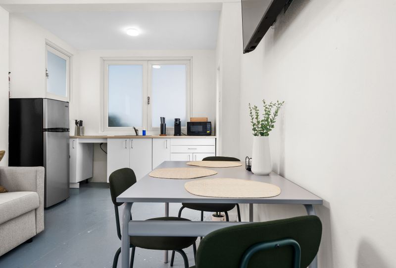 Prepare light meals and leftovers with this convenient kitchen featuring a refrigerator, sink, and microwave and a dinning area.