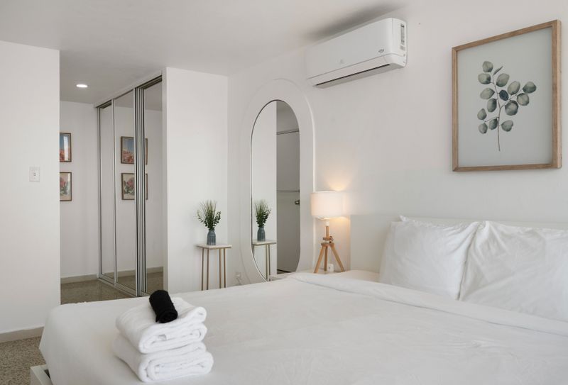 Chic bedroom with elegant archway and mirror. Get ready in style and comfort.