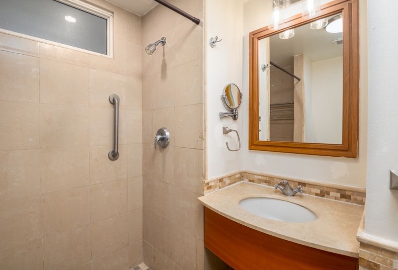 Refresh and rejuvenate in our clean, contemporary bathroom featuring a spacious shower and elegant vanity.