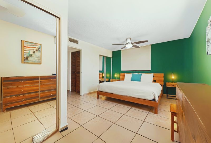 Enjoy a restful night’s sleep in this beautifully designed bedroom featuring a comfortable bed, ceiling fan for optimal air circulation, and a large mirror to enhance the space. Perfect for unwinding and getting ready for a day of adventures.