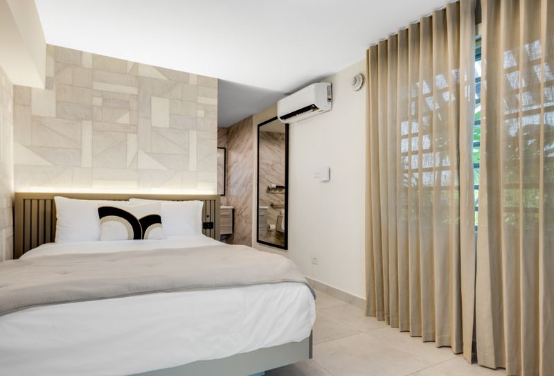 Settle into comfort on this queen-size bed, adorned with fluffy pillows and a soft, warm throw.