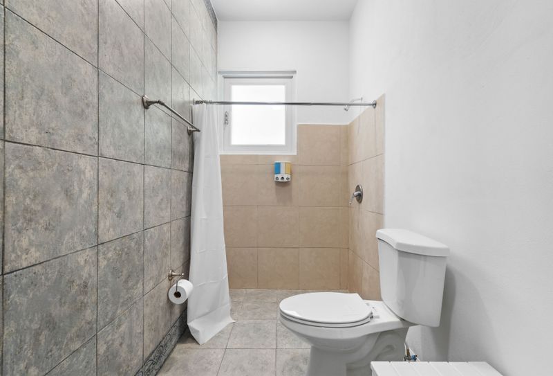 Sleek, pristine beige-tiled bathroom.