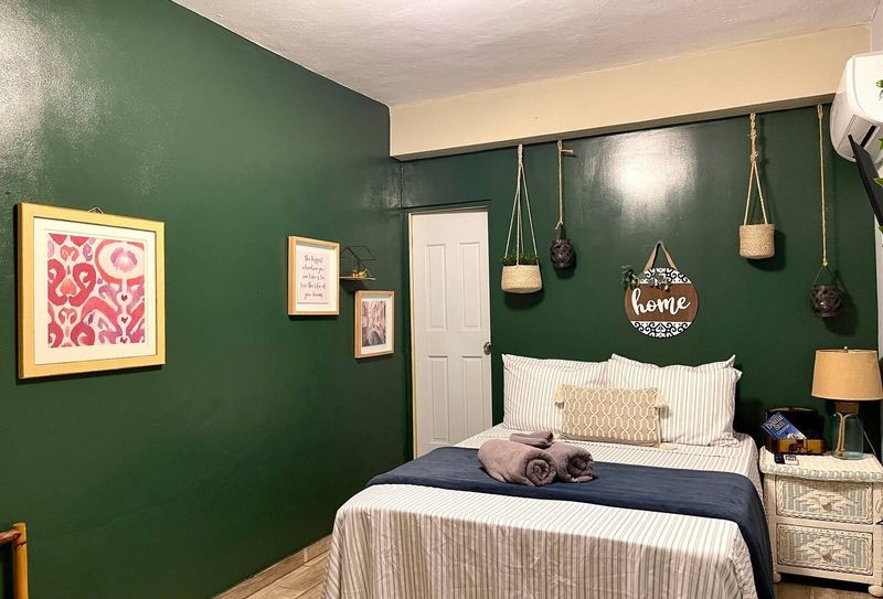 MAIN BEDROOM WITH QUEN SIZE BED AIRCONDITIONER WALL ART SOFT LINENS WITH BATHROOM