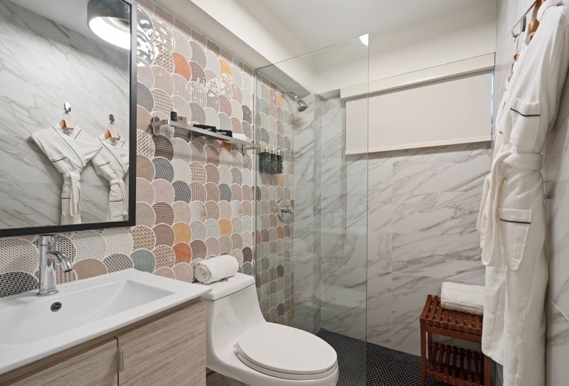 A modern bathroom with shower, bathrobe and a mirror, ideal for a quick and efficient routine.