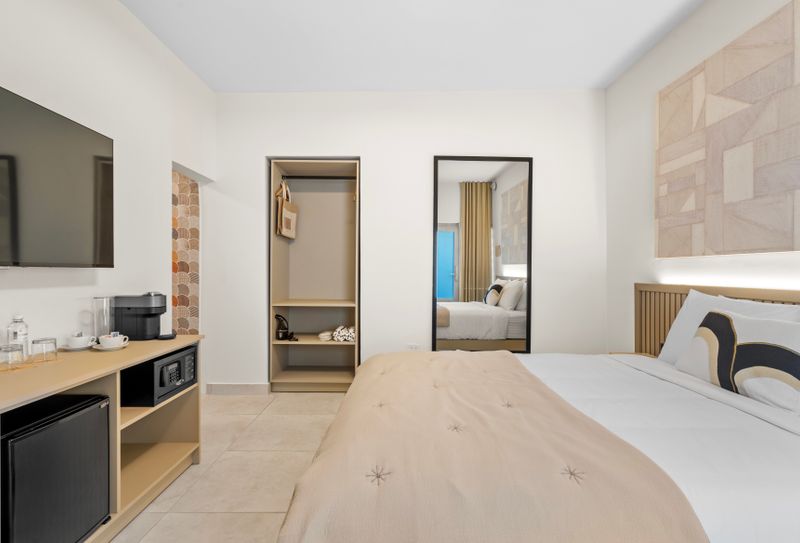 A timeless elegant bedroom features with flat screen tv and a mirror.
