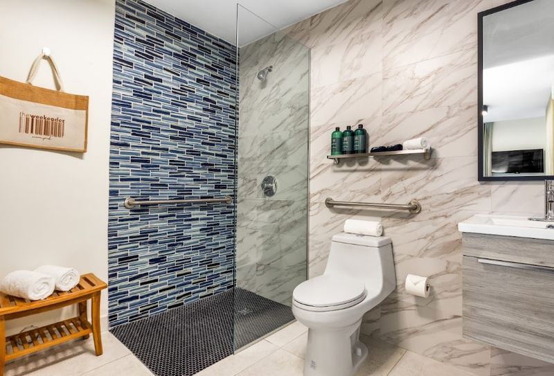 A pristine bathroom, featuring a spacious walk-in shower and a mirror, exudes a sense of tranquility and luxury.