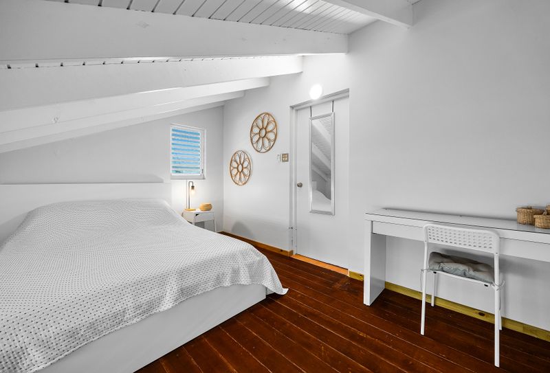 Cozy under the eaves. Sleep soundly in this peaceful space with soft lighting and beachy touches.