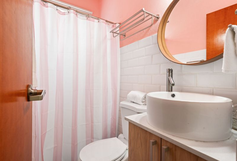 Step into a serene bathroom haven with soft hues, a charming mirror, white modern sink and cabinets , creating a calming escape in every corner.