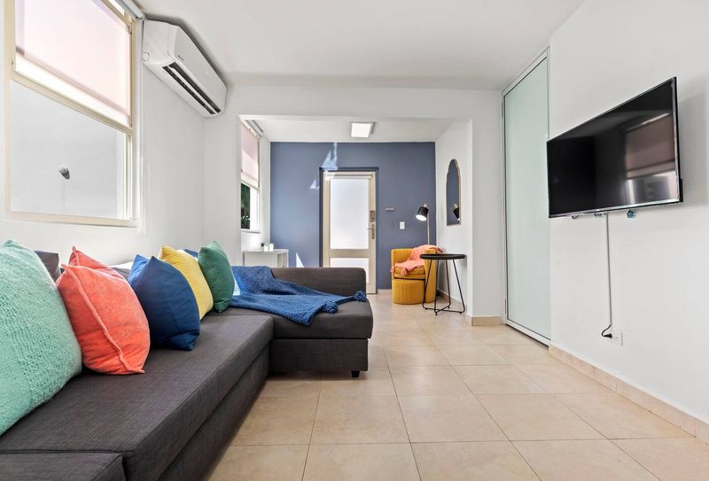 Relax in a modern living space. Our cozy sofa with colorful pillows offers the perfect spot to unwind and enjoy a comfortable stay.
