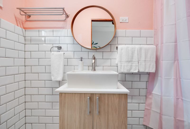 A clean and sleek bathroom with a large counter and a functional faucet.