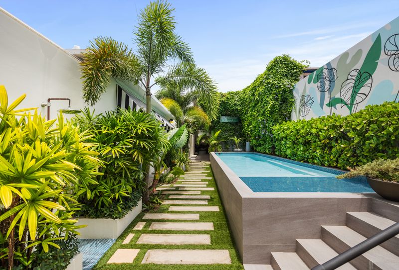 Step into tranquility at our secluded pool area, featuring vibrant tropical plants.