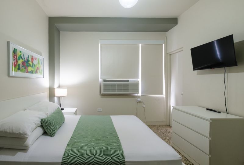 Experience ultimate comfort in our well-lit bedroom, complete with modern furnishings, blackout blinds for undisturbed sleep, and a refreshing air conditioning unit to keep you cool.