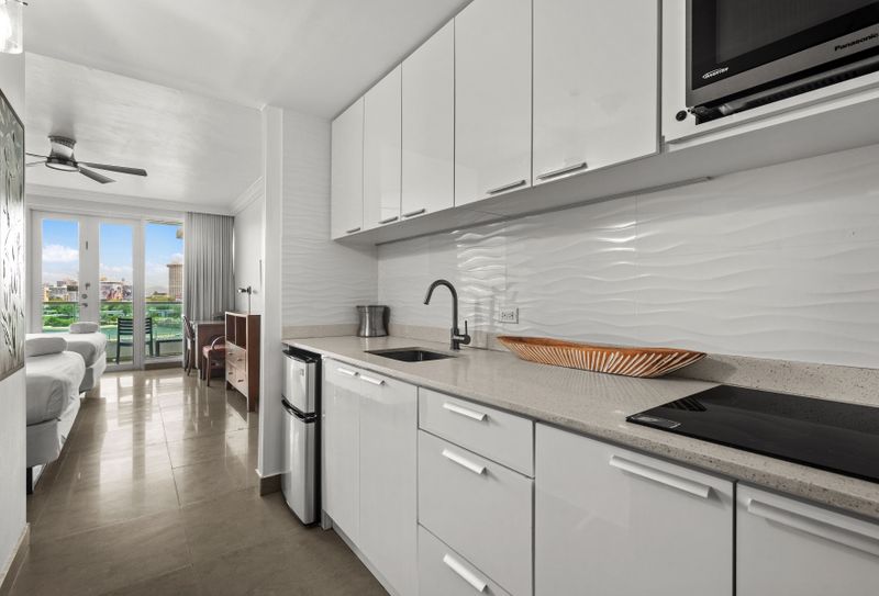 Sleek, compact kitchen leading to a bright, spacious studio with stunning views.