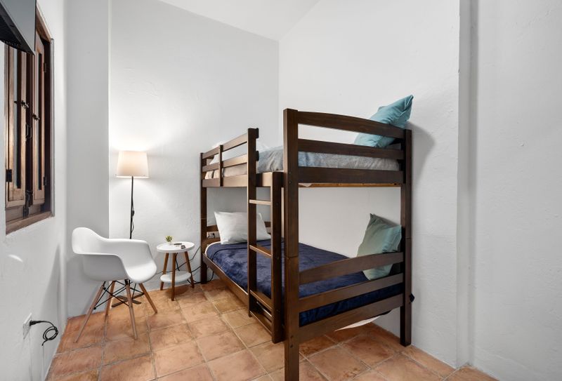 A cozy bunk bed arrangement in a sleek, modern minimalist room—ideal for friends or families traveling together.