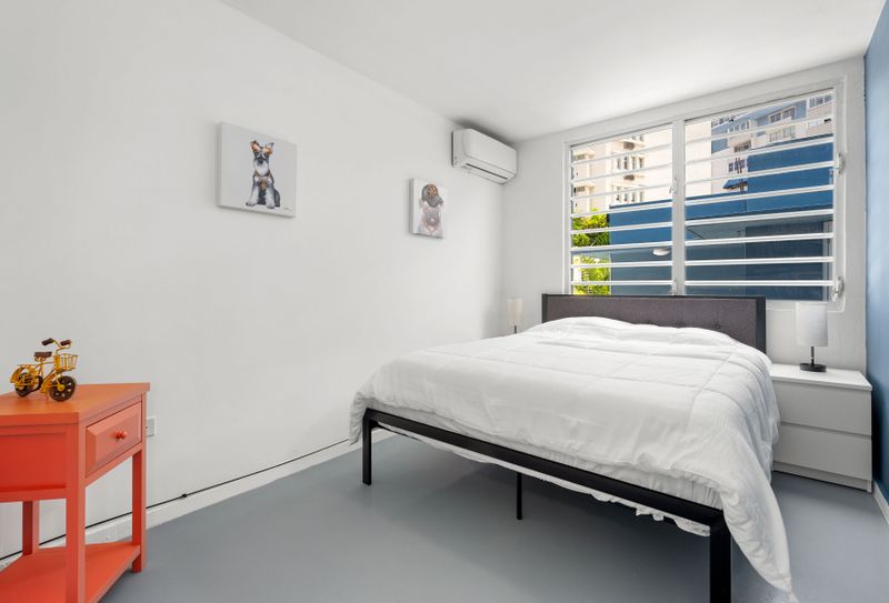 Condado | Near The Beach Condo 5 Find solace in this tranquil bedroom equipped with air conditioning for those warm days and nights - your cool oasis amidst the urban jungle.